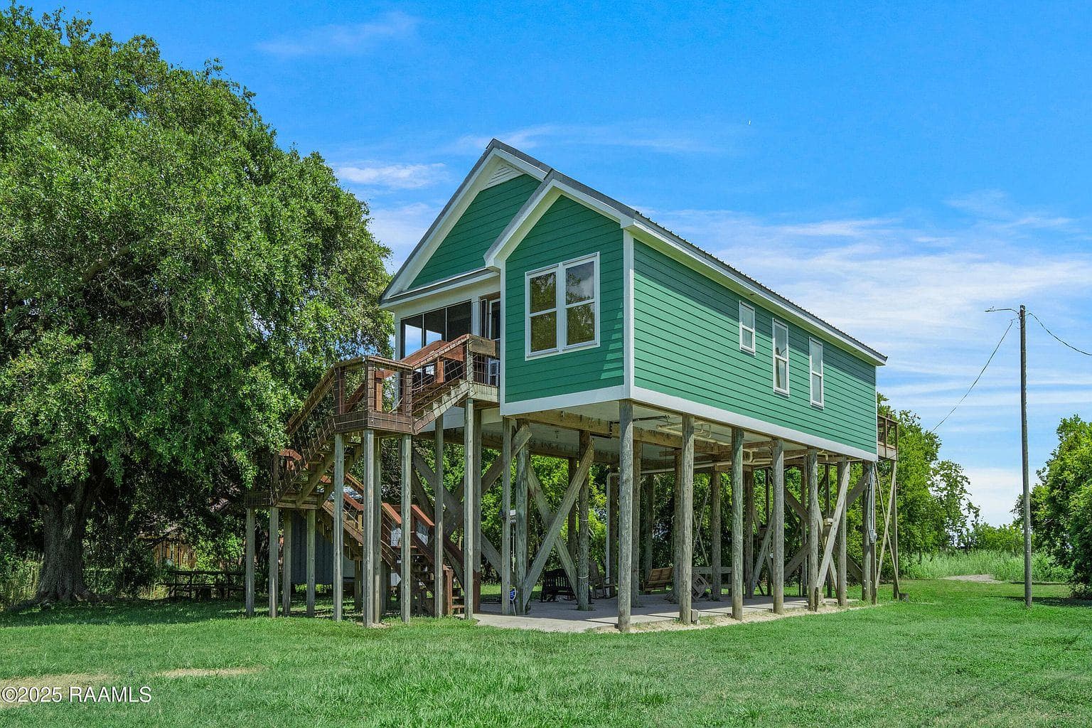 The green stilted camp seen from the yard